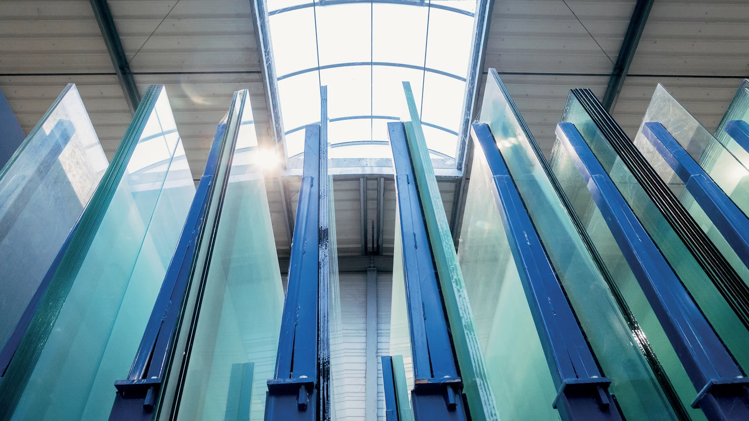 Atelier d'artisan avec &eacute;tabli noir central, murs en briques peintes blanches, grandes fen&ecirc;tres industrielles