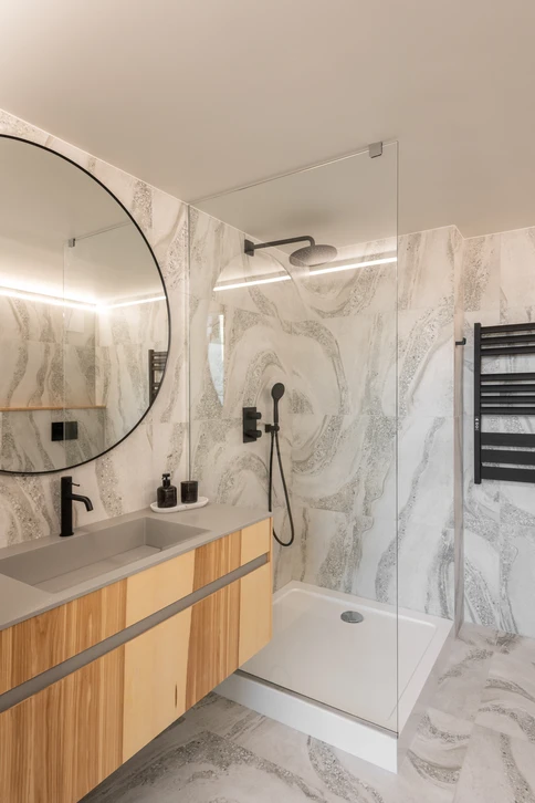 Intérieur minimaliste avec chat domestique face à un miroir de table circulaire révélant le reflet d'un lion majestueux à crinière dorée