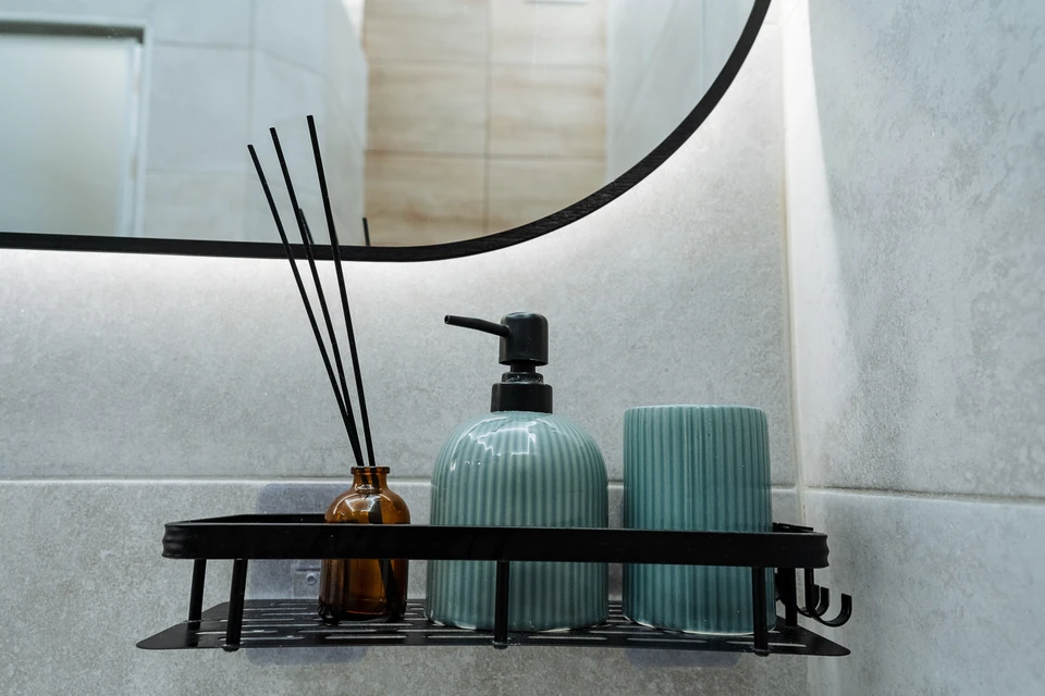 Intérieur d'atelier automobile, technicien en gants noirs utilisant une polisseuse orbitale électrique sur carrosserie blanche de véhicule