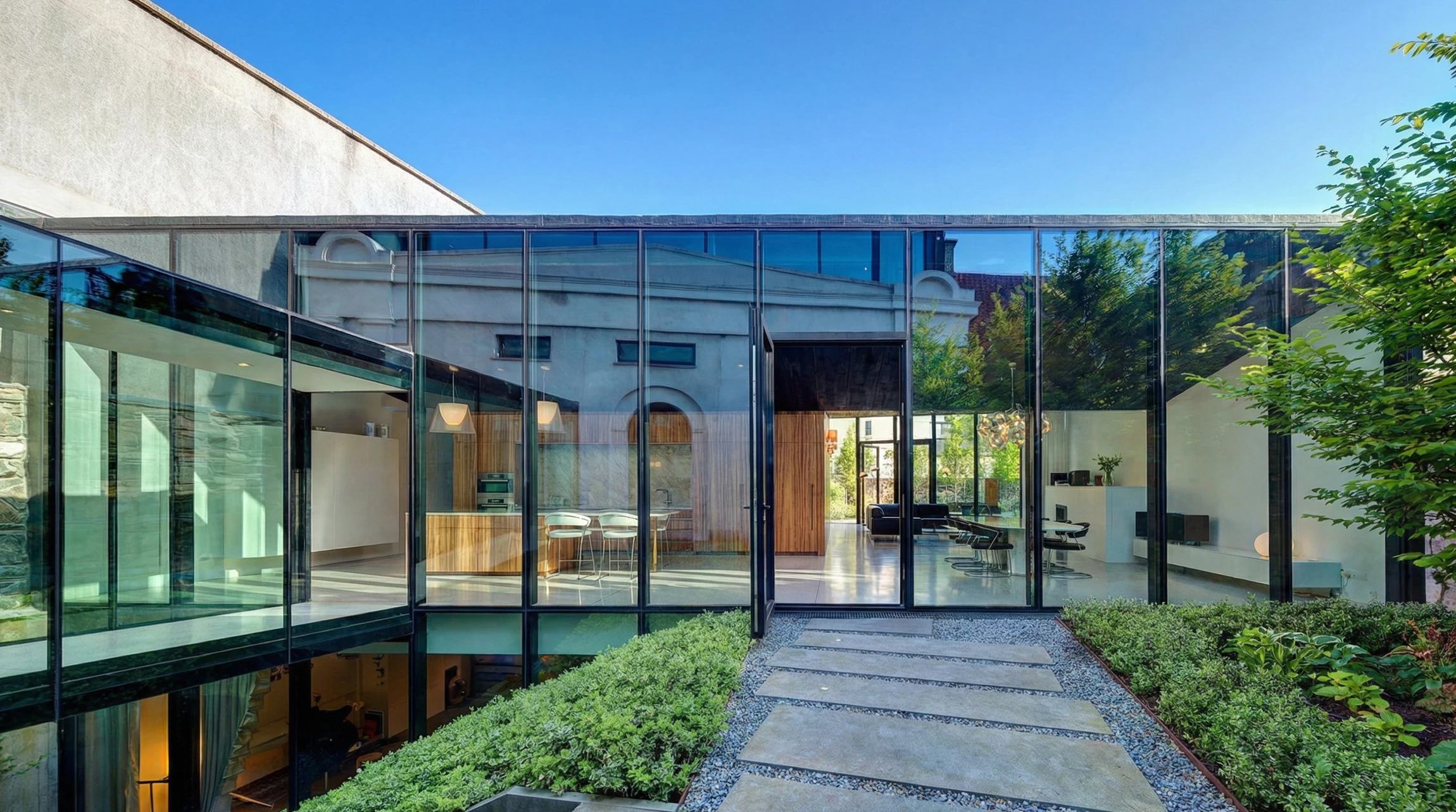 Terrasse extérieure avec deux flûtes à champagne contenant un cocktail bicolore jaune et vert, disposées sur une surface réfléchissante