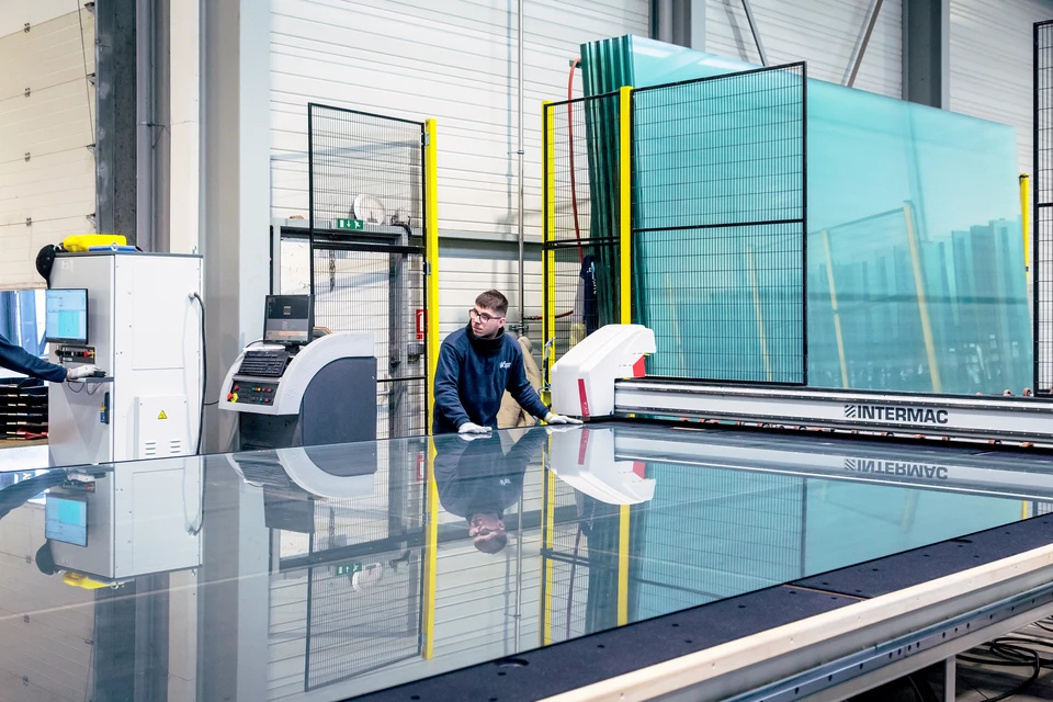 Un mécanicien professionnel change un pare-brise sur une voiture dans un atelier de voiture